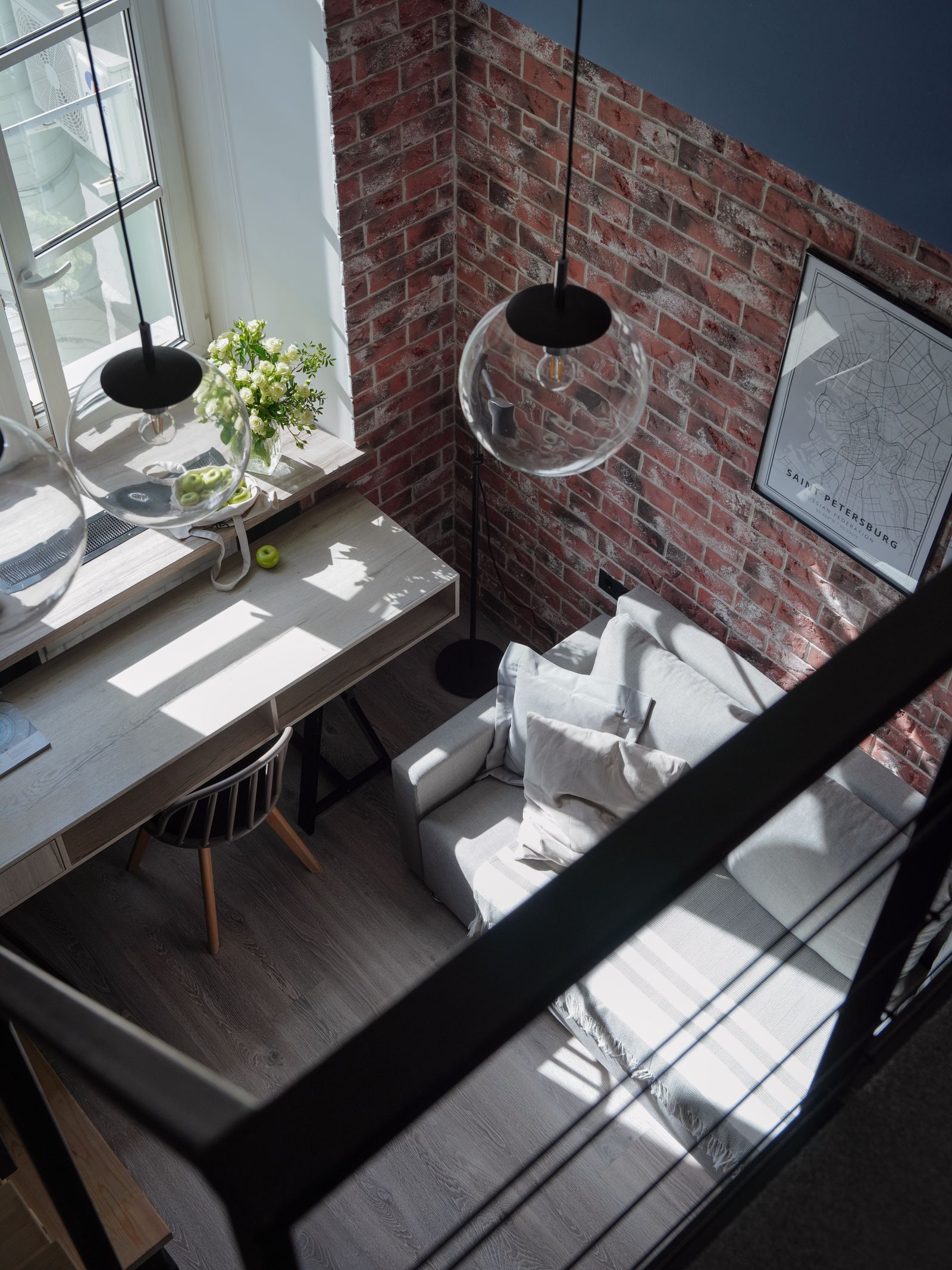 Bright modern loft with brick walls, sunlight, and contemporary furniture.