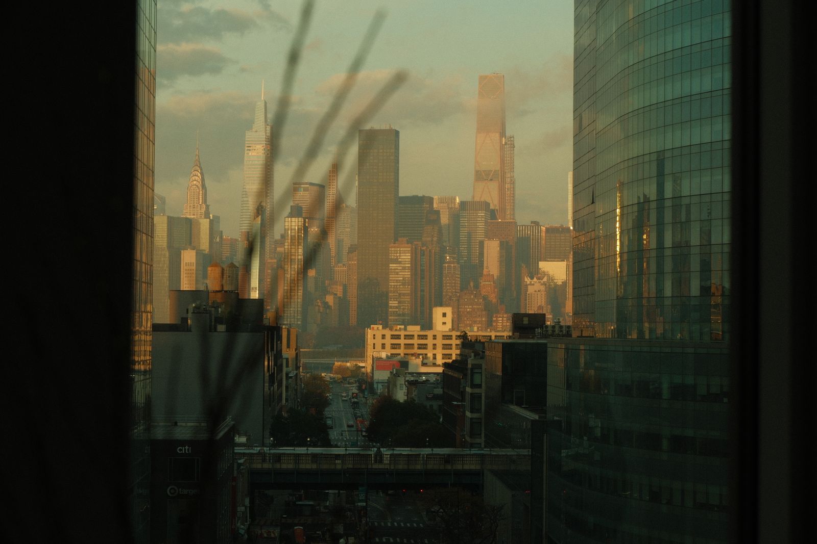 Beautiful sunset view of the New York City skyline seen through a window with modern architecture.