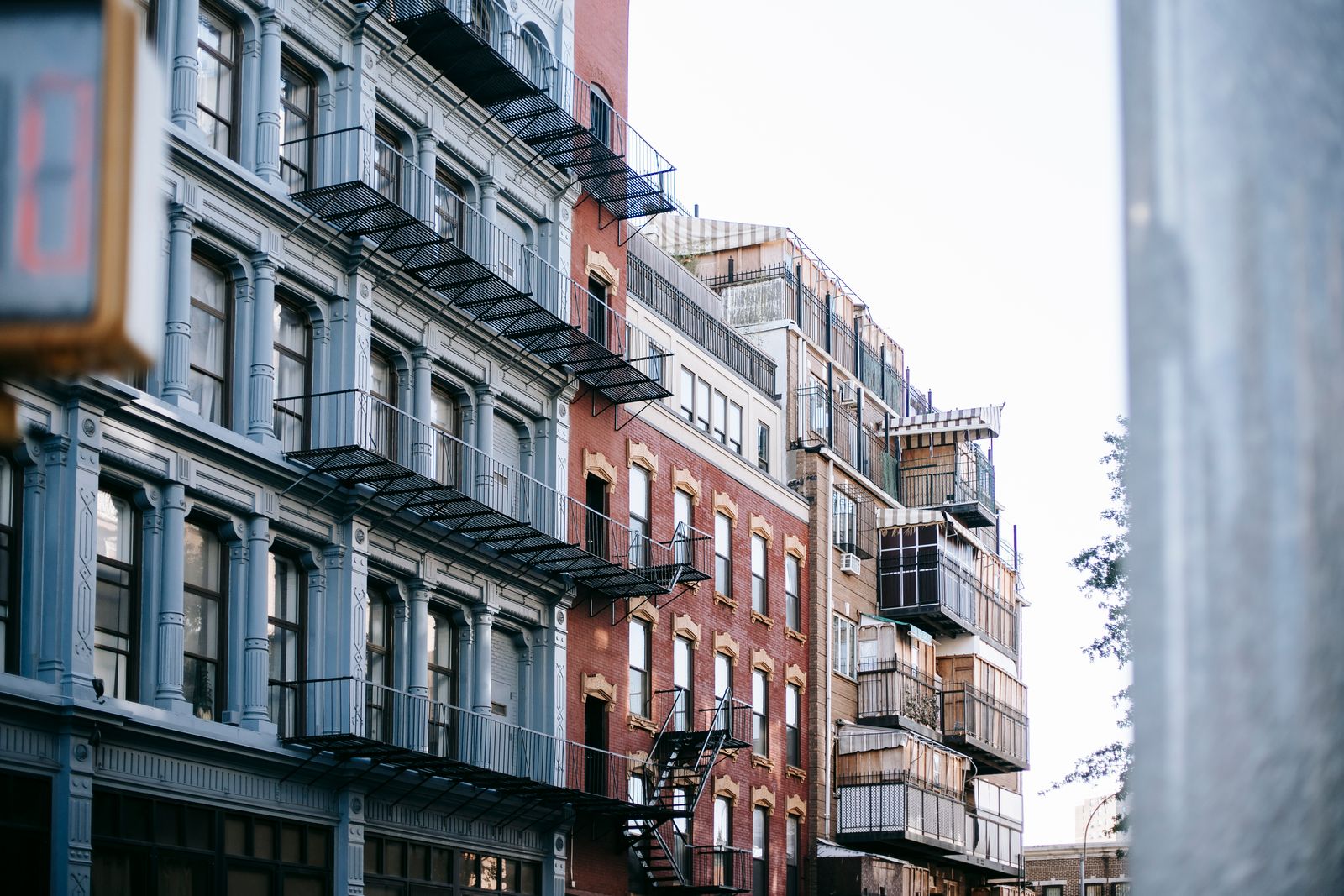 Low angle of exterior of aged colorful historic apartments with balconies and stairs on narrow street in modern city at daytime