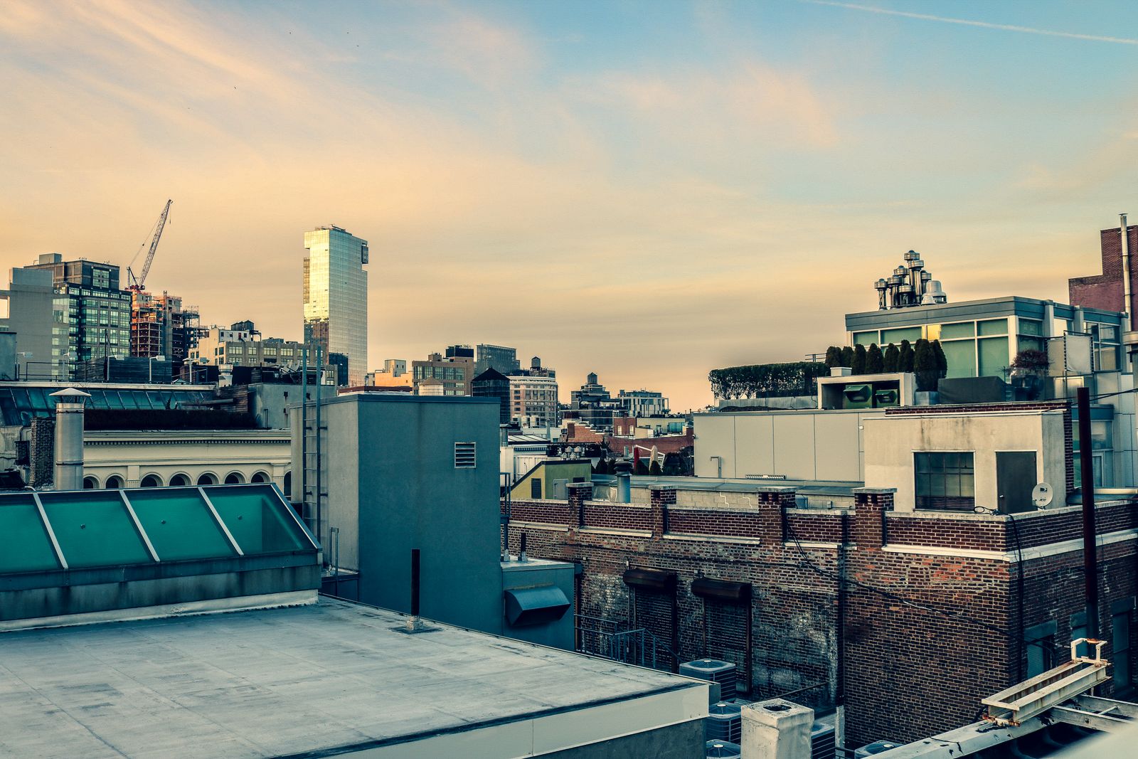 Dusk view of a New York City rooftop with modern buildings under a clear sky.